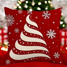 a red pillow with a white christmas tree on it