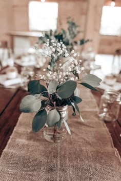 a vase filled with flowers sitting on top of a table covered in burlock