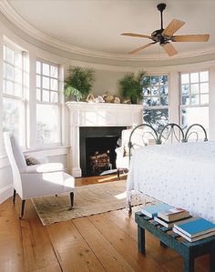 a bedroom with a bed, fireplace and two chairs in it's center room