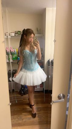 a woman in a blue corset taking a selfie