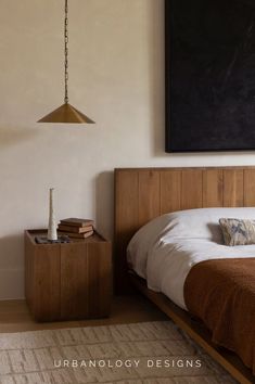 a bedroom with a bed, nightstand and painting hanging on the wall above it's headboard