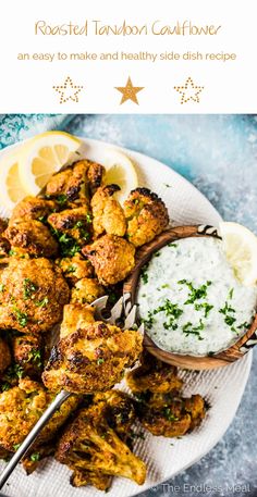 a plate full of chicken wings and rice with lemon wedges on the side next to it