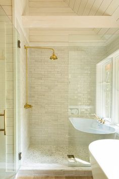 a bathroom with a walk in shower next to a bathtub and sink under a window