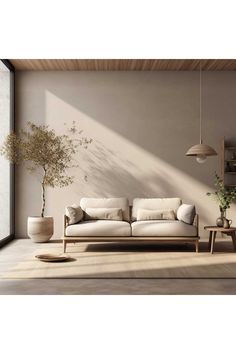 a living room with a couch, table and potted plant on the floor next to it