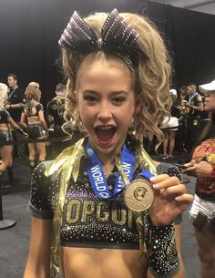 a cheerleader holding a medal in her hand