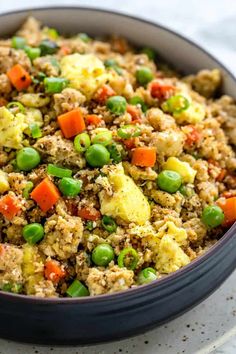 a bowl filled with rice and vegetables on top of a table