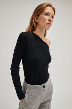 COMPOSITION: 100% Merino wool FIT: Fits true to size, take your usual size Designed for a close fit Vovk is 1.73 m (5.67 ft) tall and wears size S DESIGNER NOTES: Rib stitch Gauge 14, 1ply Slit cuff One-shoulder cut MATERIAL: 100% Extrafine merino wool Extrafine Merino Wool Merino wool is a natural fiber grown by Merino sheeps. It’s thinner than regular wool making it softer and more comfortable on your skin. When you wear it next to skin, a lot of benefits come with it. Merino wool is breathable and temperature regulating thanks to the air chambers that are within the fabric that keeps the heat close to your body. Also, Merino wool doesn’t hold on to unpleasant doors thanks to its scaly surface that makes it impossible for bacteria to set in and it can hold up to 33% of its own weight in Sustainable Knitwear, Top Pearl, Fancy Design, Rib Stitch, Shoulder Cut, Ribbed Top, One Shoulder Tops, Knit Top, Merino Wool