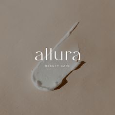 the word, allura is written in white on a beige background with a drop of liquid