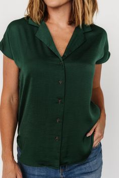 Lightweight and flowy material Deep Hunter Green color Single notched narrow lapel Button front Dropped cap sleeve Rounded, hi-low shirttail hemline Self: 100% Polyester Marianne is 5'6, cup size 34D, size 6 and wearing size S Casual Short Sleeve Blouse With Back Button Closure, Green Short Sleeve Blouse With Button Closure, Rayon Short Sleeve Blouse With Button Closure, Green Short Sleeve Blouse With Buttons, Blouse With Rolled Sleeves And Shirttail Hem, Solid Color Blouse With Rolled Sleeves And Shirttail Hem, Solid Blouse With Rolled Sleeves And Shirttail Hem, Collared Rayon Top With Buttons, Green Tops With Button Closure And Shirttail Hem