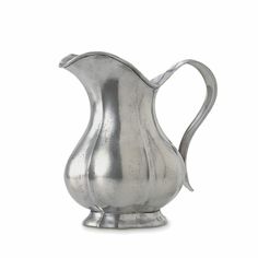 a silver pitcher sitting on top of a white surface