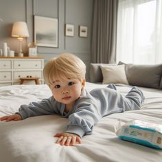 a little boy laying on top of a bed