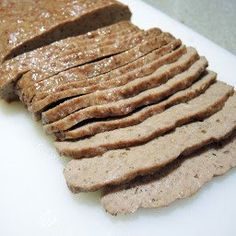 slices of meat on a cutting board with peanut butter spread over the top to make it look like they are sliced