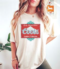 Coors vintage turquoise bead rodeo tshirt! *Thanks for stopping by! Happy Shopping!* This soft-washed, garment-dyed fabric brings extra coziness to your wardrobe while the relaxed fit makes it an excellent daily choice. The double-needle stitching throughout the tee makes it highly durable while the lack of side-seams helps the shirt retain its tubular shape.  .: The Comfort Colors 1717 tee is made with medium fabric consisting of high quality, 100% ring-spun US cotton for long-lasting comfort. .: The relaxed fit keeps the wearer comfy in both casual and semi-formal settings while the crew neckline delivers that classic, neat style which makes it perfect for accessorizing.  .: The pre-shrunk fabric ensures a consistently great fit.  .: All Comfort Colors 1717 shirts feature pre-shrunk cott Vintage Summer T-shirt For Rodeo, Summer Graphic Tee For Western-themed Events, Retro T-shirt For Western-themed Summer Events, Retro Summer T-shirt For Western-themed Events, Western Style Screen Print Tops For Summer, Retro Summer Rodeo T-shirt, Retro Summer T-shirt For Rodeo, Vintage T-shirt For Western-themed Summer Events, Retro Crew Neck Tops For Western-themed Events