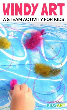 a kid's hand is painting some colorful feathers on a blue sheet with the words wind