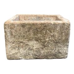 a square stone planter is shown against a white background, with the top section partially covered in dirt