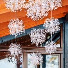 snowflakes hanging from the ceiling in front of a window