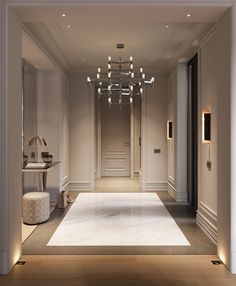 an elegant hallway with chandelier and mirror on the wall in front of it