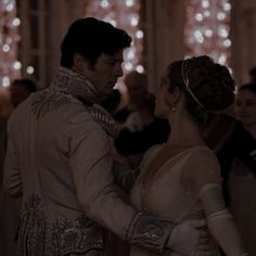 a man and woman dressed in white dance together