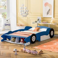 a child's car bed is shown with toys on the floor in front of it