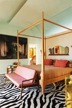 a bedroom with a zebra print rug and four poster bed