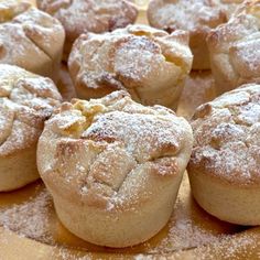 some powdered sugar covered muffins sitting on top of a table