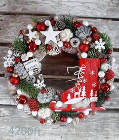 a christmas wreath with red boots, pine cones and white snowflakes on it