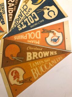 four pennants from the cleveland browns and tampa buccaneers football teams, all in different colors