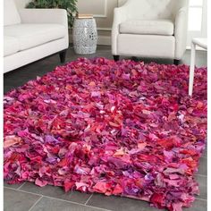 a living room with a rug made out of pink and red paper machs on the floor