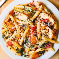 a white plate topped with pasta and chicken