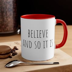 a red and white coffee mug with the words believe and so it's on it