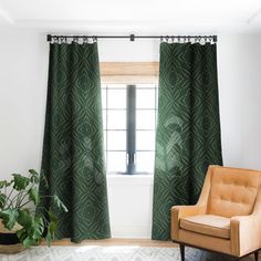 a living room with green curtains and a brown chair in front of a large window