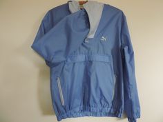 "Vintage Puma Athletic Wear Wind Breaker. Unisex Track Wear. Puma size M Trendy Sporty Puma Hoodie, Wind Breaker, Workout, Athletic Jacket. Awesome Puma Track and Field Jacket. Workout Casual Unisex Sports Wear. Track and Field warm Jacket, Front Zip Jacket. The Jacket is Blue featuring Powder Blue Accent Front Zip and Hoodie. It features Vintage Puma logo, including Trendy Metal Puma Cat Pull on Front Zipper. The Jacket features Pockets in front, and at Chest. Elastic waist and wrists.  Jacket Sports Windbreaker With Kangaroo Pocket And Long Sleeves, Casual Sports Windbreaker With Kangaroo Pocket, Casual Windbreaker With Kangaroo Pocket For Sports, Sporty Windbreaker With Kangaroo Pocket, Sportswear Outerwear With Kangaroo Pocket, Sporty Outerwear With Kangaroo Pocket For Sports, Sporty Hiking Outerwear With Kangaroo Pocket, Soccer Jacket, Puma Hoodie