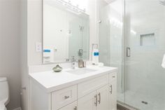 a white bathroom with a glass shower door