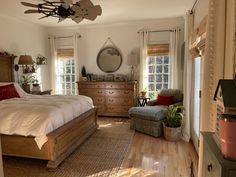 a bed room with a neatly made bed and a chair in front of a window