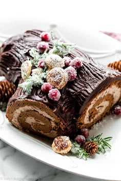 a piece of chocolate cake on a plate with pine cones