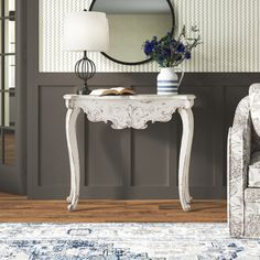 a living room with a chair, table and mirror