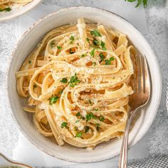 a white bowl filled with pasta and parmesan cheese