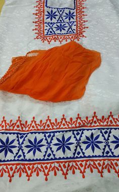 an orange and blue dress laying on top of a table