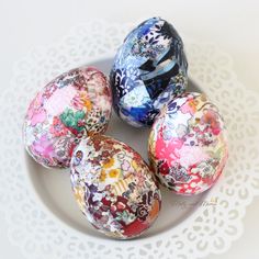 four decorated easter eggs on a white plate