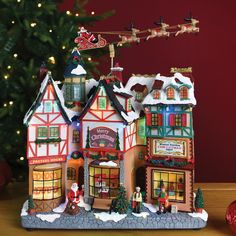 a christmas scene with a store and tree in the background