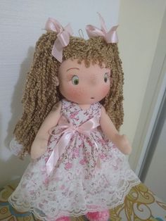 a doll with curly hair wearing a pink dress