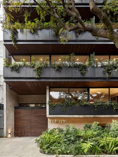 an apartment building with plants growing on the balconies