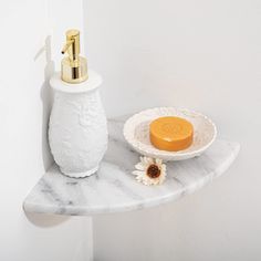 a soap dispenser sitting on top of a shelf next to a flower