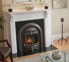 a living room filled with furniture and a fire place in front of a mirror on the wall