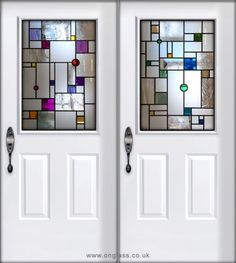 two white double doors with stained glass panels on each side and the same door handle