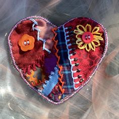 a heart shaped box with buttons and flowers on it