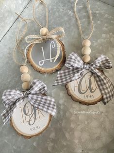 three wood slice ornaments with monogrammed ribbons