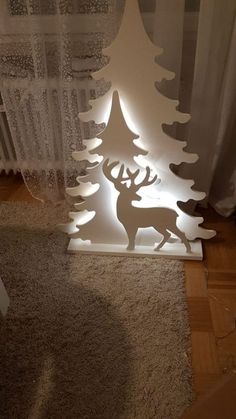 a lighted christmas tree with a deer on it