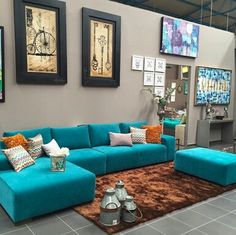 a living room with blue couches and pictures on the wall above them in a showroom