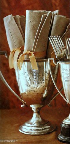 there are many silver cups with utensils in them